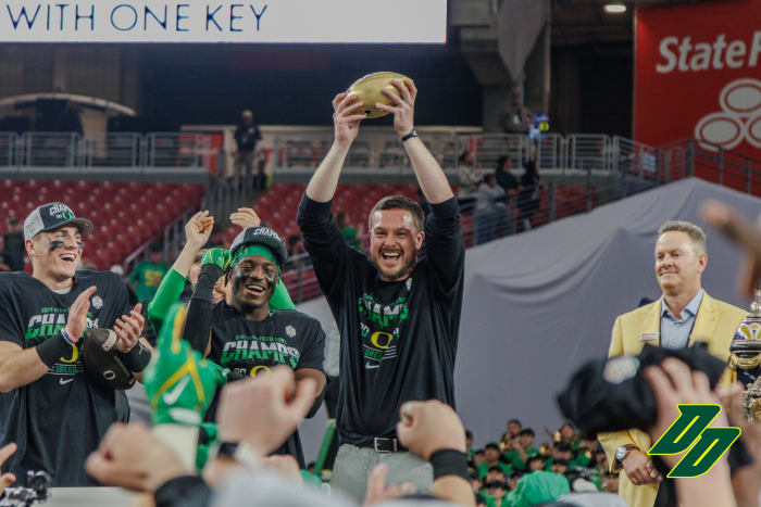 Oregon Ducks head coach Dan Lanning raises the Vrbo Fiesta Bowl trophy after a 45-6 win over the Liberty Flames.